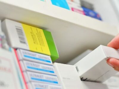 pharmacist pulling prescription from shelf